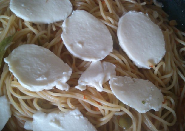 Fotografia przedstawiająca spaghetti z czosnkiem, oliwkami i mozzarellą