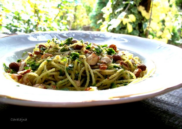 Fotografia przedstawiająca spaghetti z orzechami laskowymi i zieloną pietruszką
