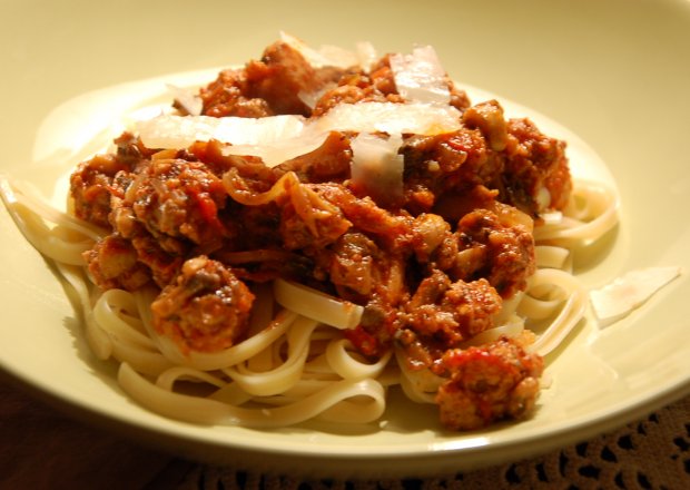 Fotografia przedstawiająca spaghetti z sosem pomidorowym, mięsem i pieczarkami