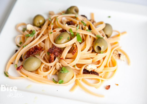 Fotografia przedstawiająca Spaghetti z zielonymi oliwkami, papryczką chilli i suszonymi pomidorami