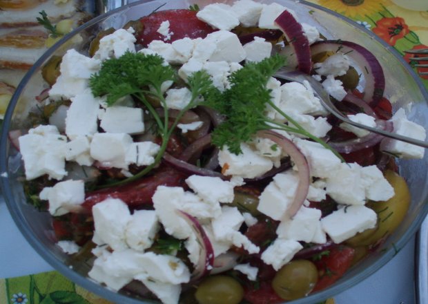 Fotografia przedstawiająca surówka z serem fera, pomidorami i oliwkami