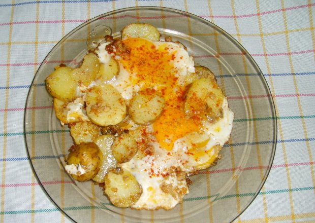 Fotografia przedstawiająca syte śniadanie z jajkami na ziemniakach
