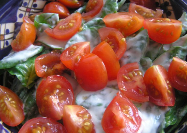 Fotografia przedstawiająca Szpinak z sosem serowym i pomidorkami cherry.