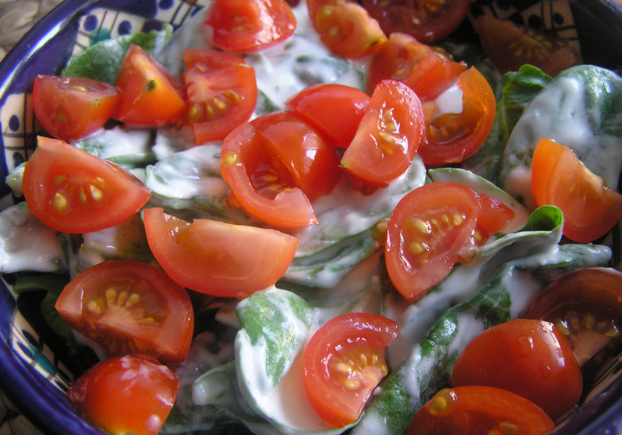 Szpinak z sosem serowym i pomidorkami cherry. foto