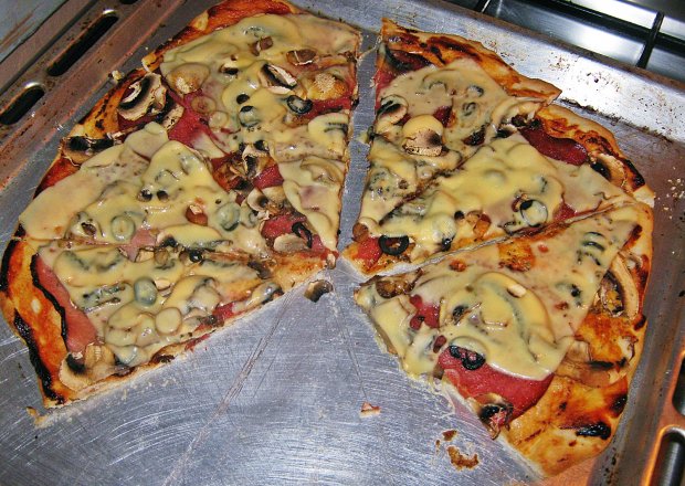 Fotografia przedstawiająca Szybka pizza z salami i czarnymi oliwkami