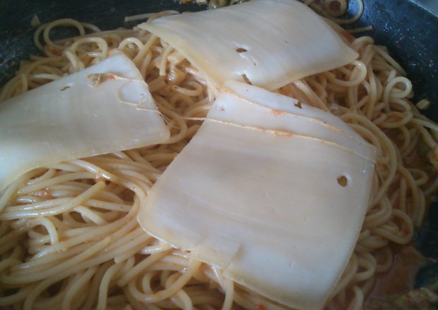 Fotografia przedstawiająca Szybkie spaghetti z żółtym serem i oliwkami