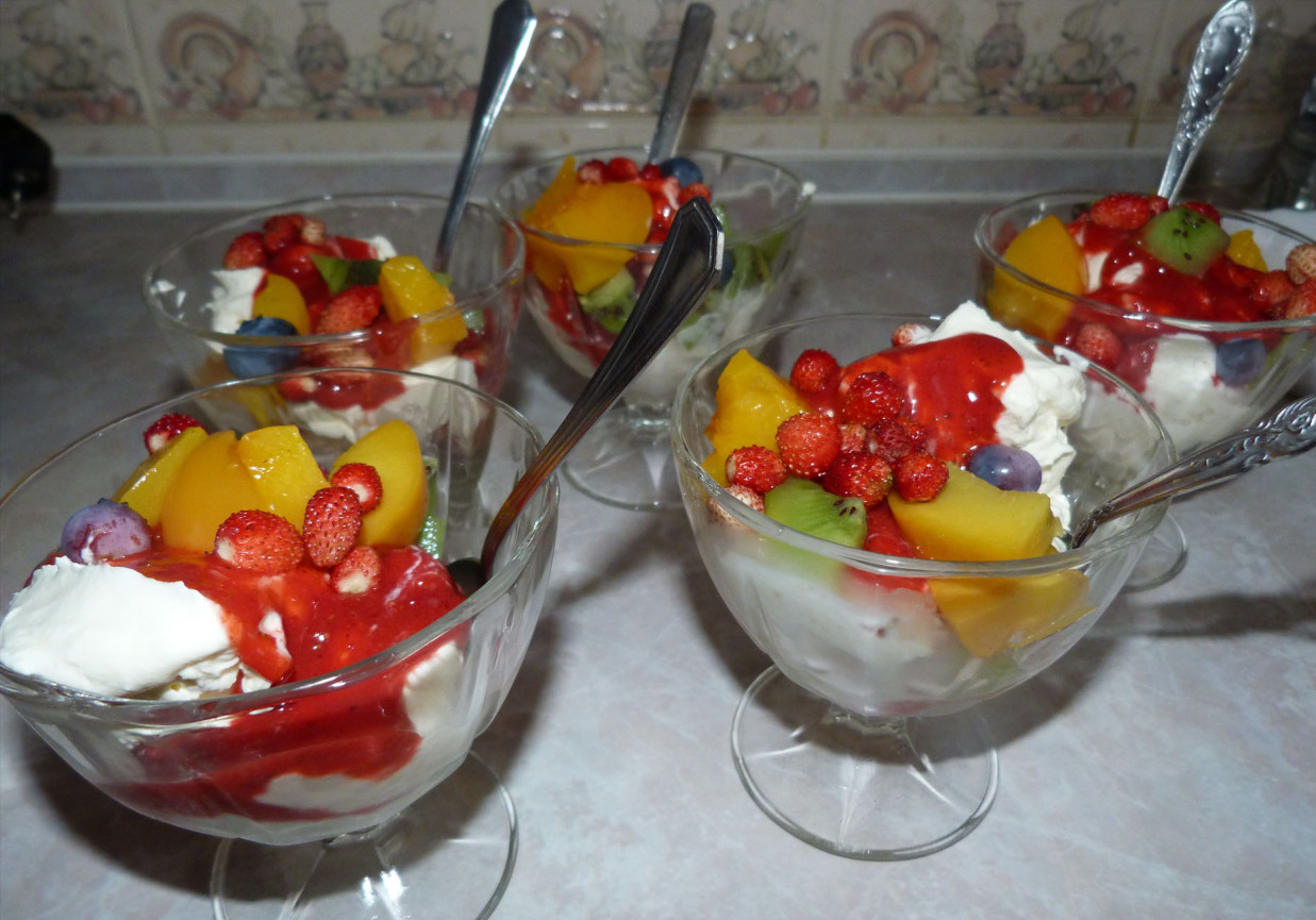 tęczowe lody z owocami i bitą śmietaną z polewą truskawkową foto
