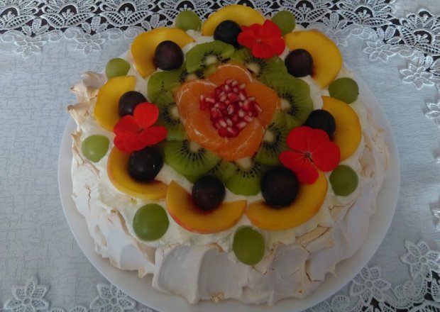 Fotografia przedstawiająca Tort bezowy z sosem z mango, kremem i owocami