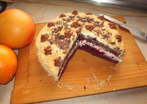 Fotografia przedstawiająca Tort czekoladowy z malinami i kremem waniliowym