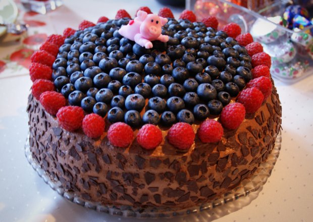 Fotografia przedstawiająca tort czekoladowy z owocami leśnymi