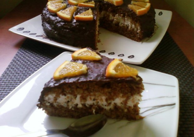 Fotografia przedstawiająca Tort marchewkowy miodowo cynamonowy - polany czekoladą o smaku pomarańczy