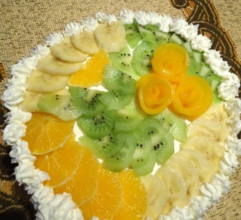 Fotografia przedstawiająca Tort śmietanowy z brzoskwiniami, ananasem, bananami i kiwi