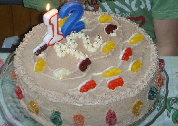 Fotografia przedstawiająca tort urodzinowy czekoladowy z biała masa w środku
