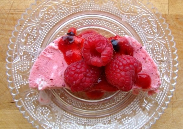 Fotografia przedstawiająca Truskawkowe semifreddo z jagodami i sosem owocowym podane z malinami