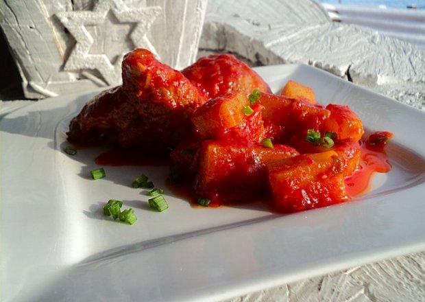 Fotografia przedstawiająca Udka duszone z ziemniakami w sosie paprykowo pomidorowym