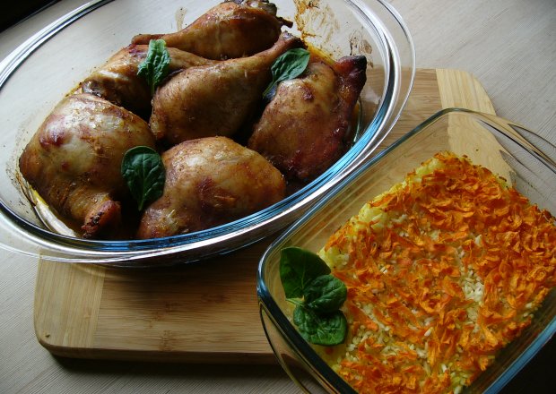 Fotografia przedstawiająca Udka kurczaka z koncentratem pomidorowym podane z pieczonym ryżem