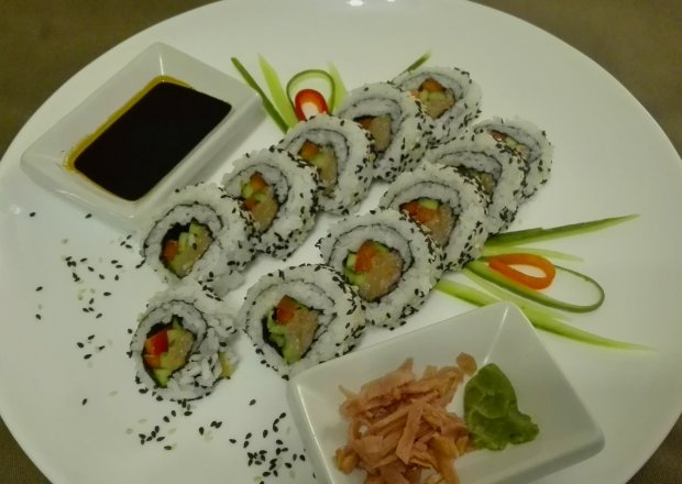 Fotografia przedstawiająca Uromaki sushi z łososiem, ogórkiem i papryką