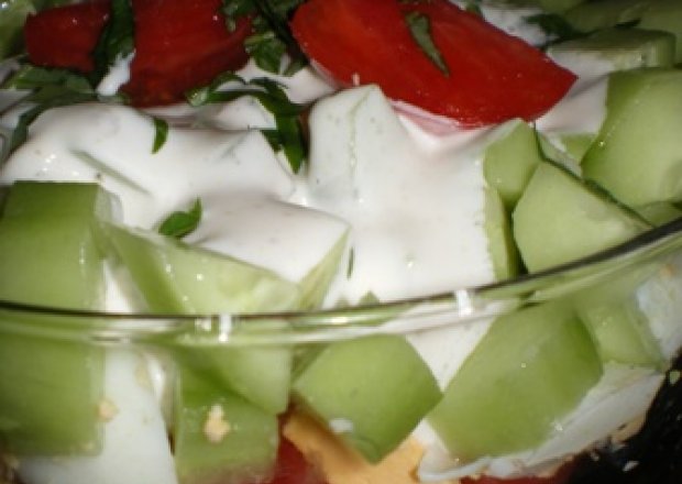 Fotografia przedstawiająca Warstwowa sałatka z jaj, pomidorów i ogórków z sosem czosnkowym