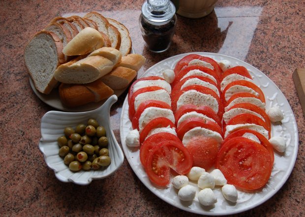 Fotografia przedstawiająca włoska prosta kolacyjka z mozzarellą i oliwkami