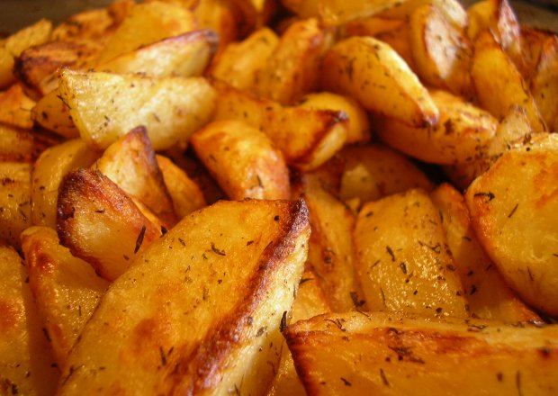 Fotografia przedstawiająca Zdrowe frytki - ziemniaki zapiekane w piekarniku w marynacie ziołowej