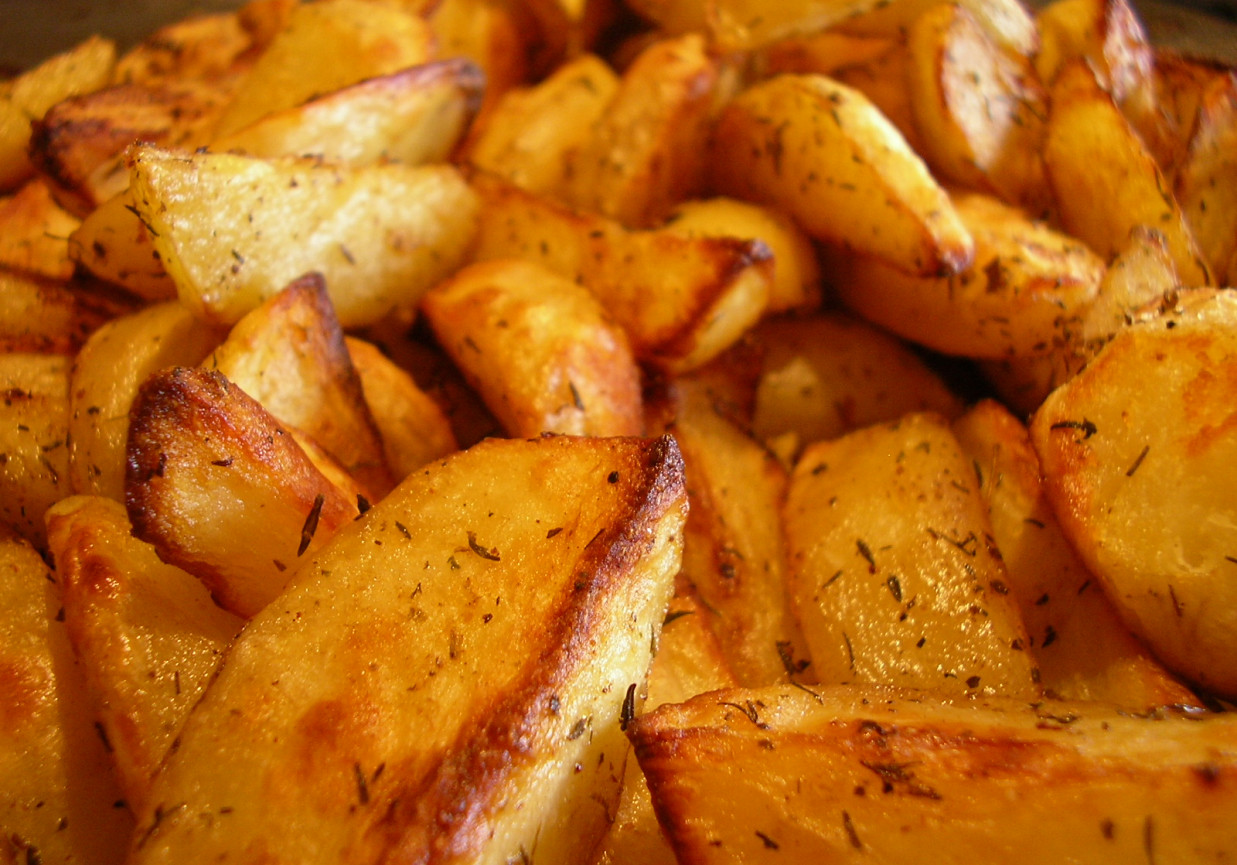 Zdrowe frytki - ziemniaki zapiekane w piekarniku w marynacie ziołowej foto