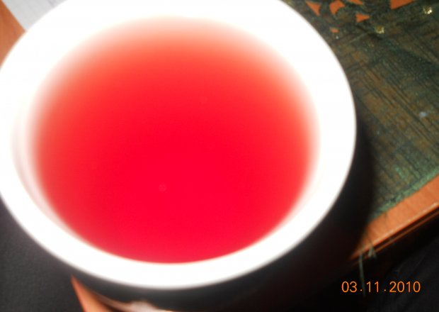 Fotografia przedstawiająca zielona herbata z sokiem malinowym i miodem