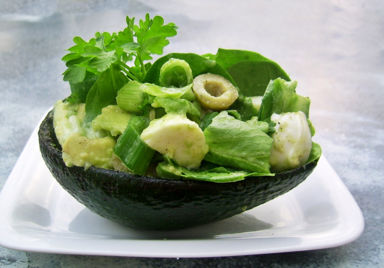 Zielona sałatka w łódeczkach avocado z dressingiem cytrynowym foto