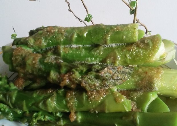Fotografia przedstawiająca Zielone szparagi polane bułką tartą
