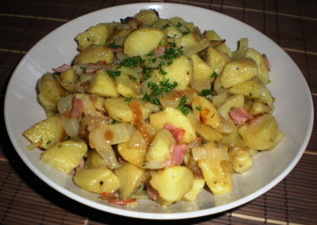Fotografia przedstawiająca Ziemniaki z cebulką i wędliną smażone na maśle
