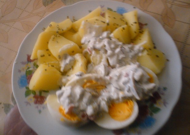 Fotografia przedstawiająca ziemniaki z jajkami z sosem