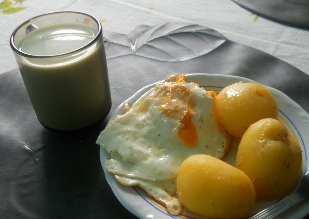 Fotografia przedstawiająca ziemniaki z jajkiem sadzonym i mlekiem