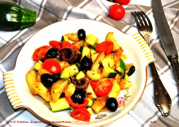 Fotografia przedstawiająca Ziemniaki z patelni z cukinią, pomidorami i oliwkami