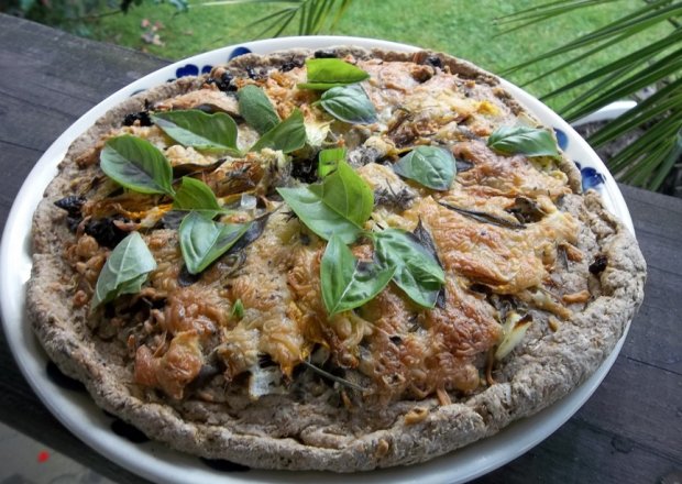 Fotografia przedstawiająca ziołowo - kwiatowa pizza na razowym chlebowym spodzie