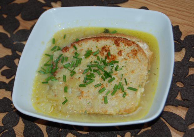 Fotografia przedstawiająca Zupa cebulowa z kanapką francuską.