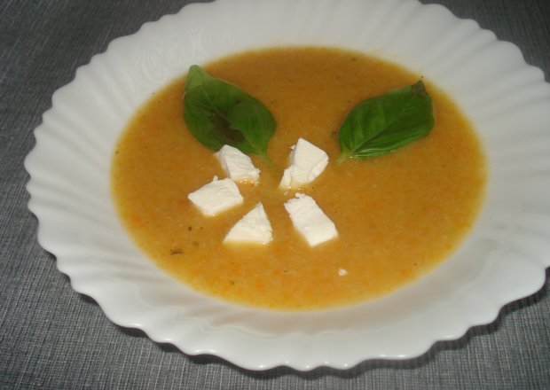 Fotografia przedstawiająca Zupa krem z marchewki podana z fetą i bazylią