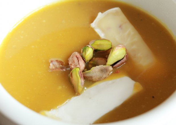 Fotografia przedstawiająca Zupa krem z pieczonej dyni z solonymi pistacjami i serkiem brie