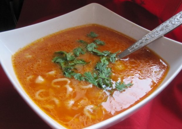 Fotografia przedstawiająca Zupa pomidorowa z koralikami i pietruszką