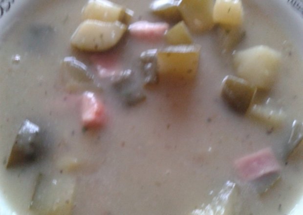 Fotografia przedstawiająca zupa ziemniaczono-cebulowy krem z kiełbasą i ogórkiem kiszonym
