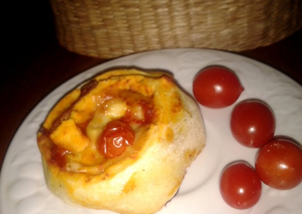 Fotografia przedstawiająca zwijana pizza z cukinią i pomidorkami